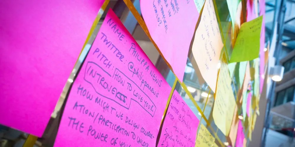 A photo of the pitch board, with many multi-colour sticky notes posted.